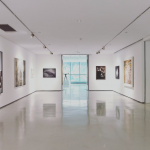 a wide shot of an indoor art exhibition showing multiple high quality prints