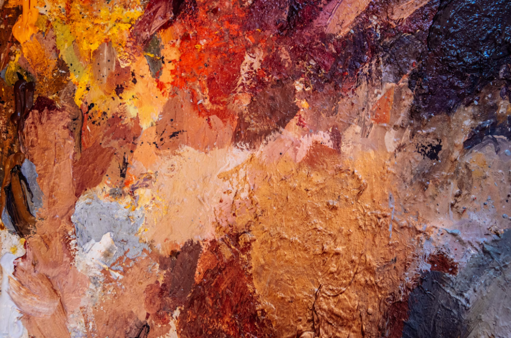 a close up of vivid brown, orange, red, purple, and yellow oil painting brushstrokes